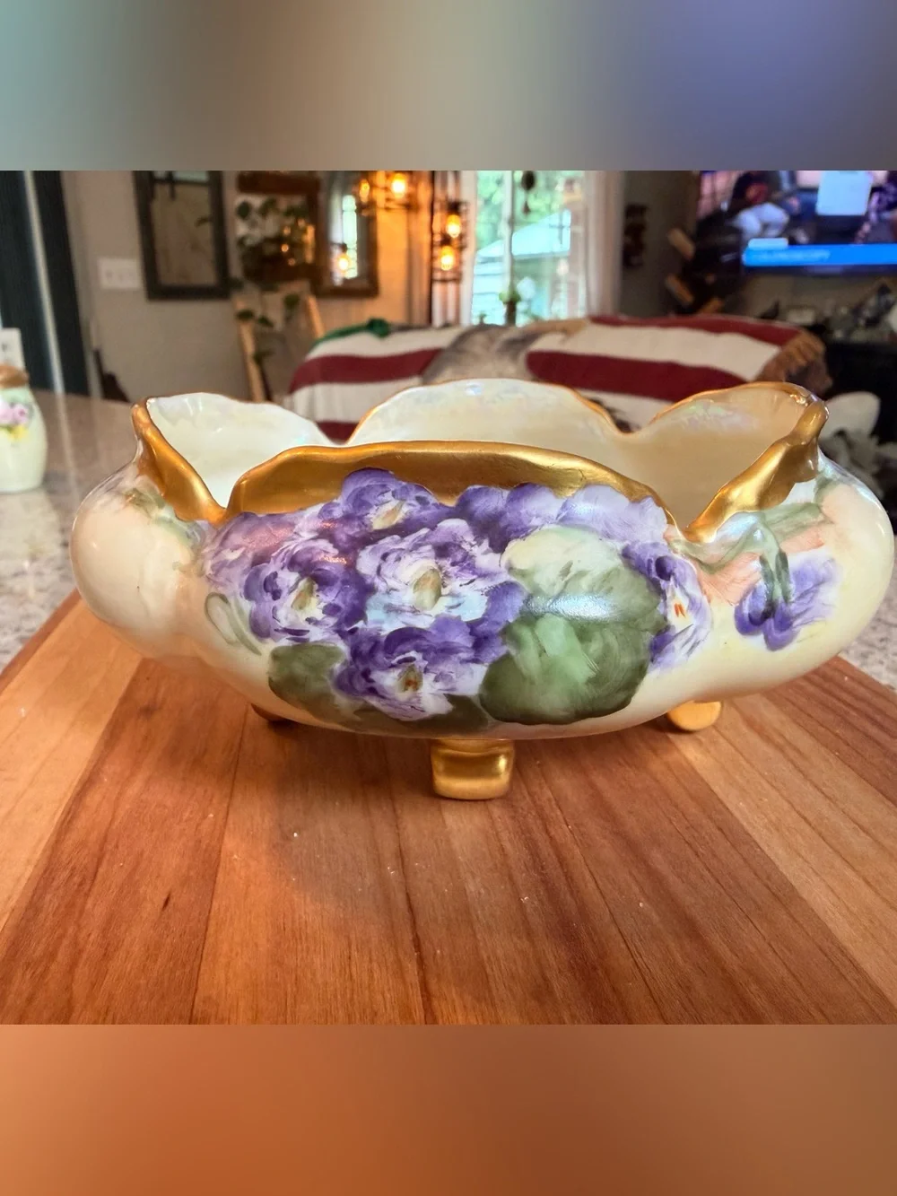 A hand-painted porcelain footed bowl with gilded rim and floral decoration.